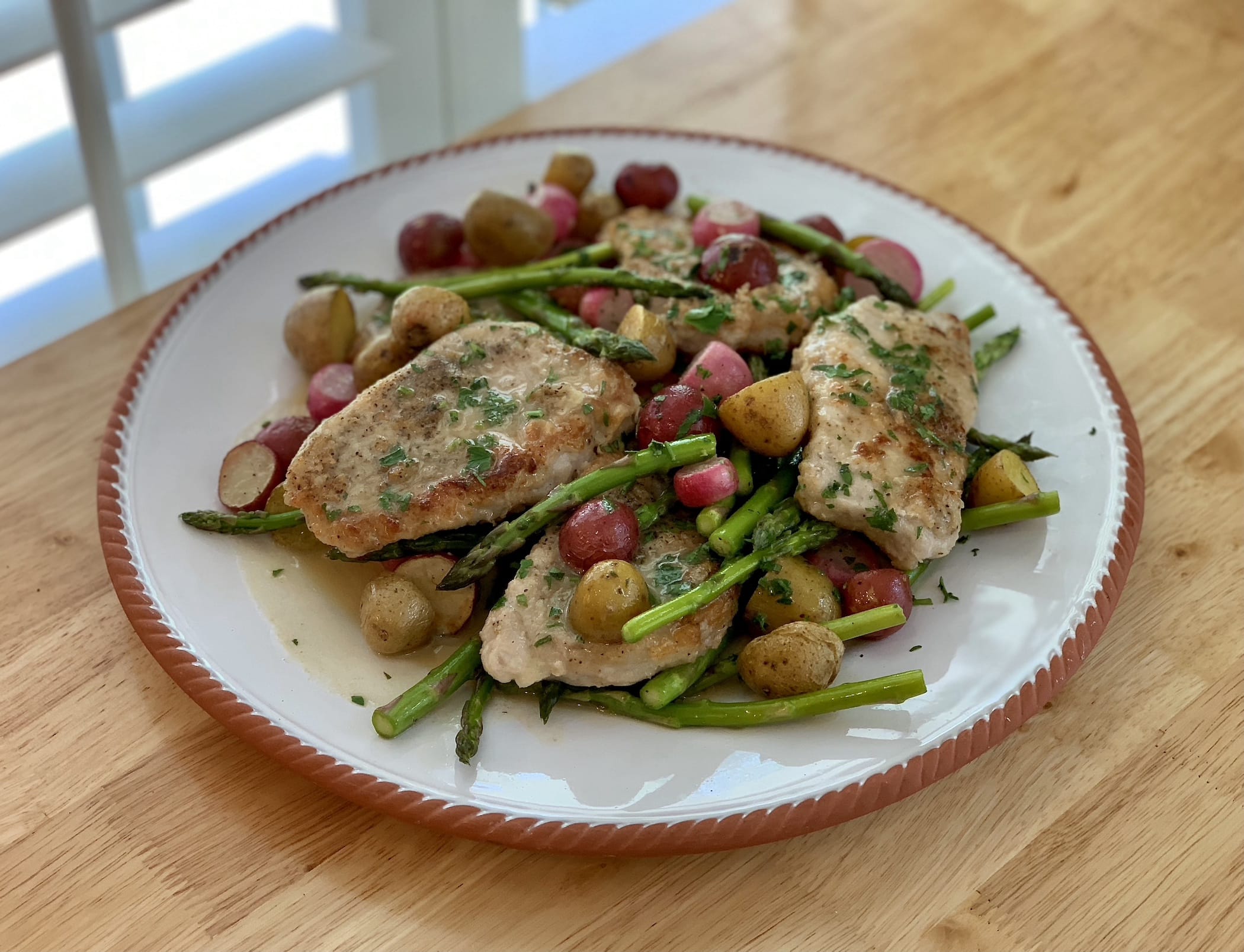 Thinly sliced pork chops teamed with baby potatoes, radishes and asparagus in a yummy anchovy butter sauce.