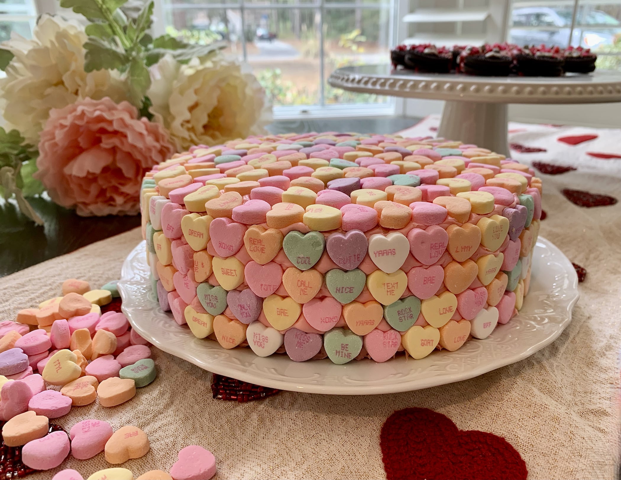 Strawberry or lemon cake/frosting garnished with conversation heart candies.